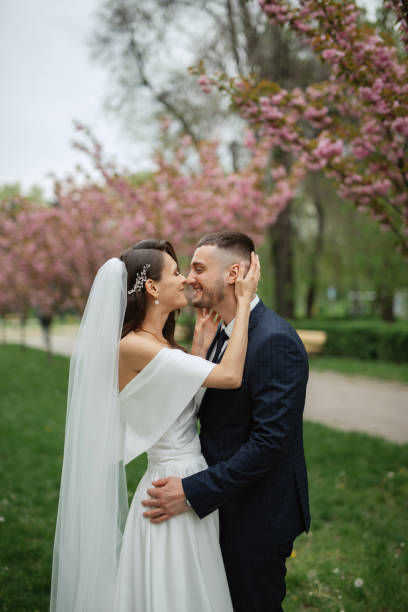 istock newlyweds walk in the park among cherry blossoms 1467110604