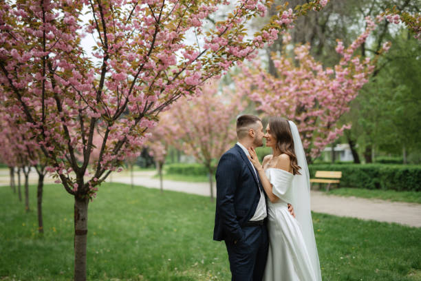 istock newlyweds walk in the park among cherry blossoms 1467112172