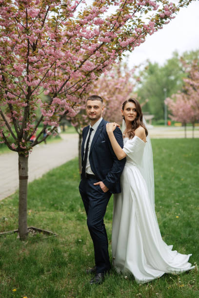 istock newlyweds walk in the park among cherry blossoms 1467112247