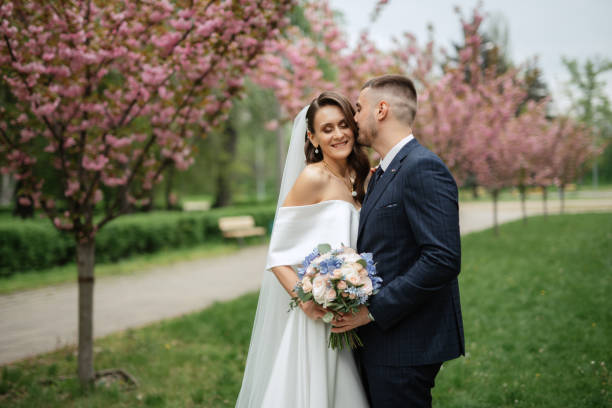 istock newlyweds walk in the park among cherry blossoms 1467112456