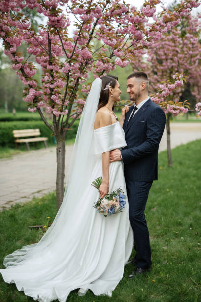 istock newlyweds walk in the park among cherry blossoms 1467112602