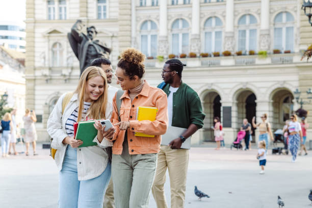 istock Two female students using smart phone on the street and talking 1467112714