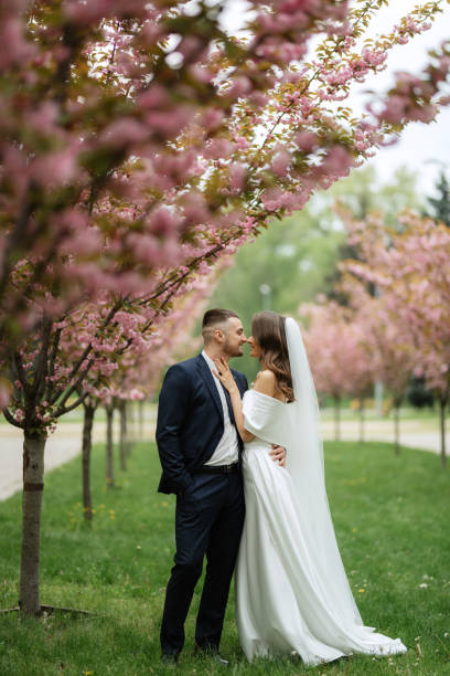 istock newlyweds walk in the park among cherry blossoms 1467112899