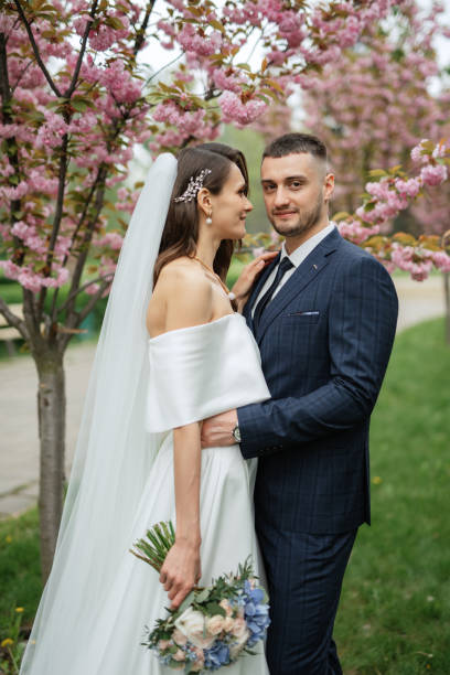 istock newlyweds walk in the park among cherry blossoms 1467113531