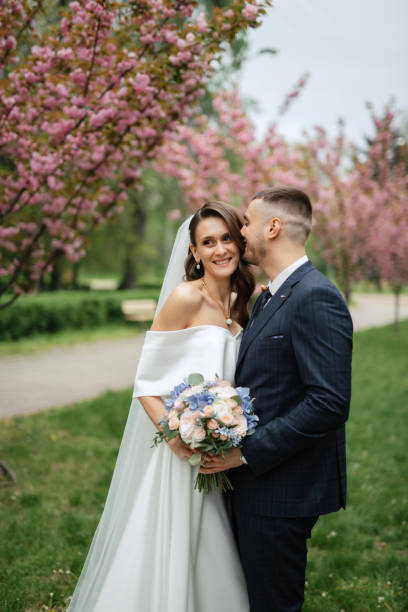 istock newlyweds walk in the park among cherry blossoms 1467113555