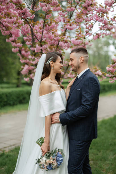 istock newlyweds walk in the park among cherry blossoms 1467113593