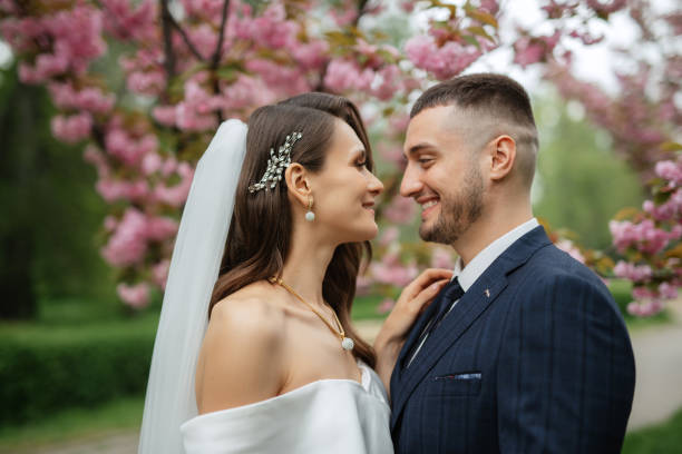 istock newlyweds walk in the park among cherry blossoms 1467113784