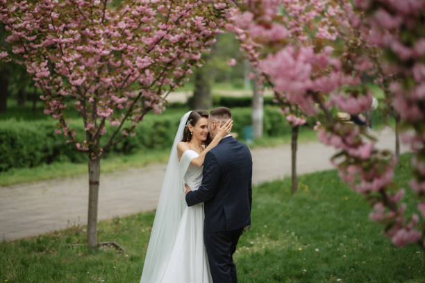istock newlyweds walk in the park among cherry blossoms 1467113919