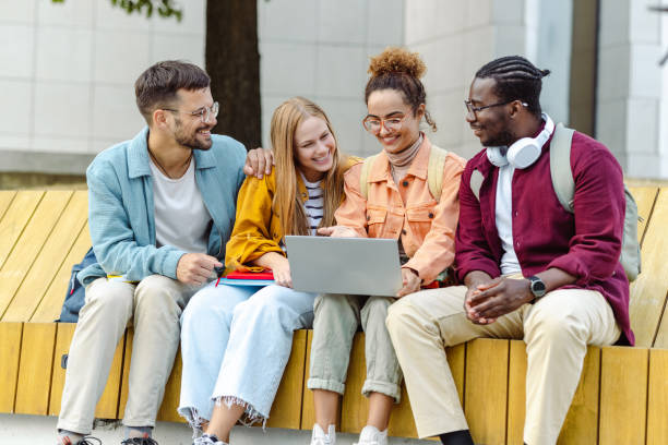istock Hanging out on campus. Young group of students using laptop 1467114055