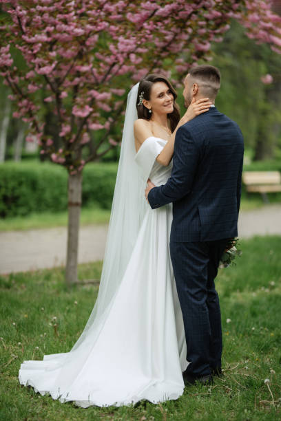 istock newlyweds walk in the park among cherry blossoms 1467114578