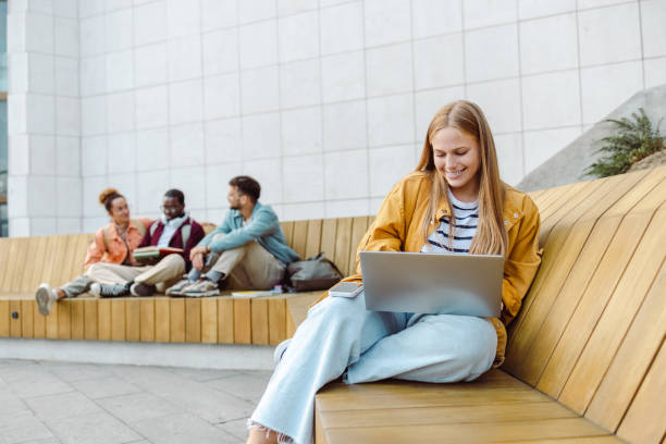 istock Young female student using laptop on the bench 1467115977