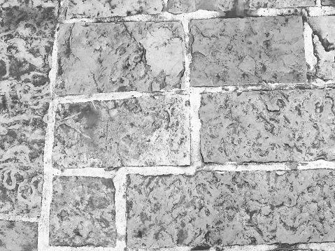 Cobblestone tiles street with big stones, top view. Ancient stone floor. Old pavement for a poster, calendar, post, screensaver, wallpaper, postcard, cover, web. Gray toned high quality photography