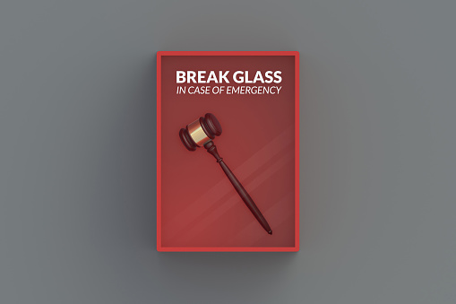 Judge gavel in red emergency box on gray wall. 3d render