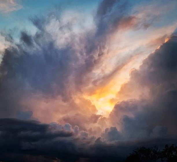 Sun appears from behind dark clouds Sun who appears, surrounded by dark clouds, pink, violet and dark blue clouds, some black végétations at the bottom of the landscape dramatic sky stock pictures, royalty-free photos & images