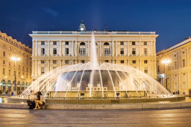 Genoa, Italy - December 3: Main fountain with splashes of water in Ferrari Square against backdrop of beautiful architecture of city. Piazza de Ferrari in Genoa, Liguria, Italy