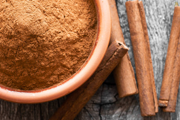 Cinnamon sticks and cinnamon powder on dark rustic background, healthy spice, (Cinnamomum) stock photo