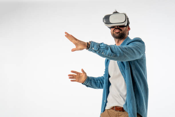 istock young handsome man with virtual reality goggles on white background. copy space 1467126665