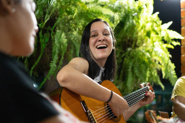 istock Woman playing guitar at home 1467127844
