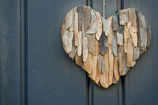 Front door with decorative heart made of drift wood pieces