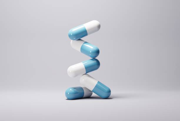 таблетки, синие капсулы на светлом фоне. - antibiotic pain cut out bottle стоковые фото и изображения
