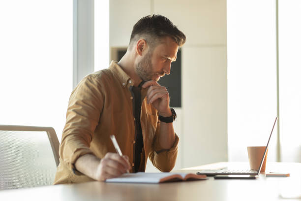 istock Businessman Writing Taking Notes Making Business Report Sitting In Office 1467141047