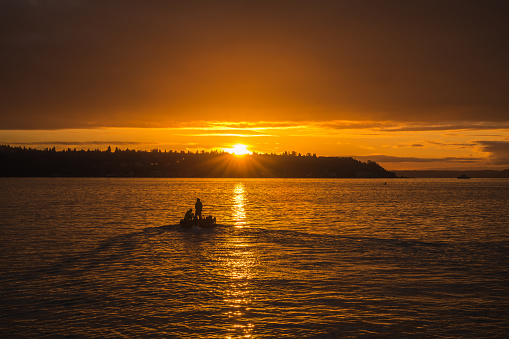 Seattle, USA - Jan 23rd, 2023: Sunset over Elliott Bay as construction workers pass while working on the the new Pier.