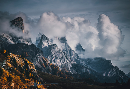 Landscape view of The Dolomites Peaks and mountain hills capped with clouds and fog on a sunny day from Passo Rolle to Baita Segantini Circuit Hike and pale di San Martino, Trentino Alto Adige,  North Italy. They are a group of mountain ranges of the Italian Alps. World Heritage Site of Unesco.