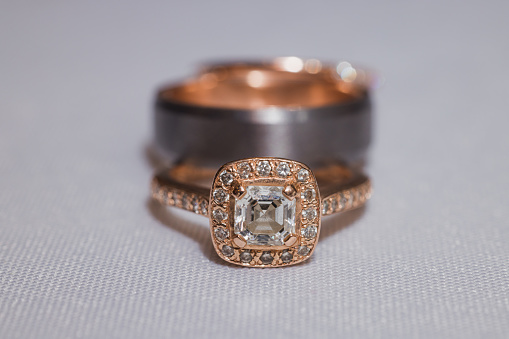 Two wedding rings together on a white table cloth. Shot with a 100mm macro lens for close up detail.