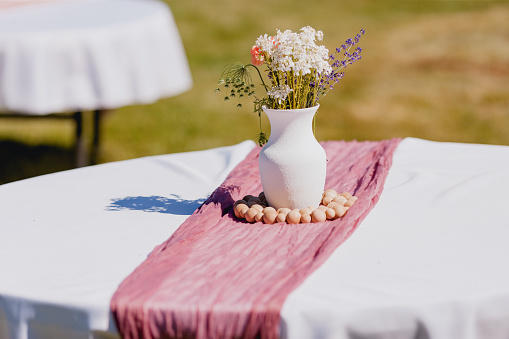 Large group of white tables and chairs for a formal event, such as a wedding reception or anniversary party.