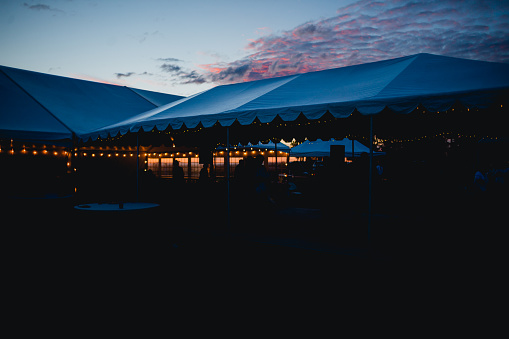Beautiful outdoor wedding reception at twilight as the sun sets. Shadows increased to make any faces unrecognizable.