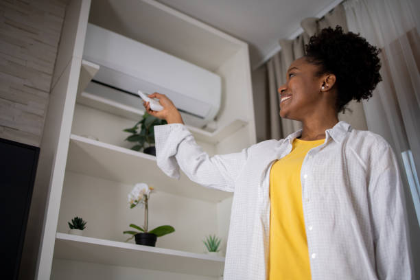istock Young woman turning on air conditioner 1467150238