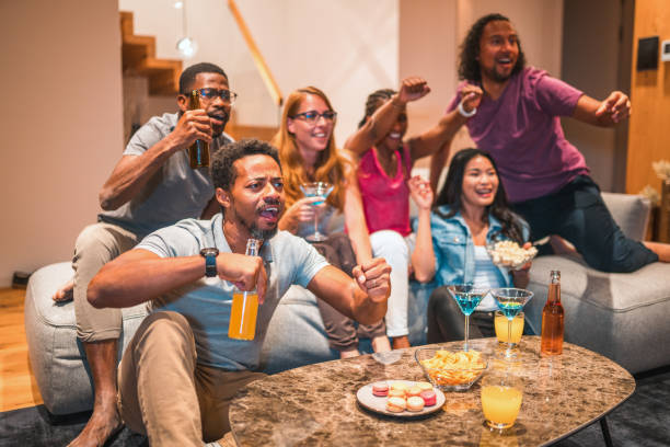 istock Mixed Race Cousins Watching A Basketball Match And Drinking Alcohol 1467150451