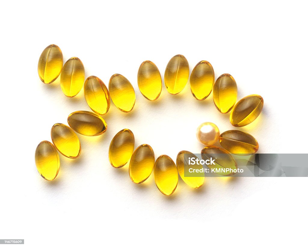 Omega 3 capsules forming the shape of a goldfish omega 3. healthcare and medicine products - yellow gel capsules. fish shape Capsule - Medicine Stock Photo