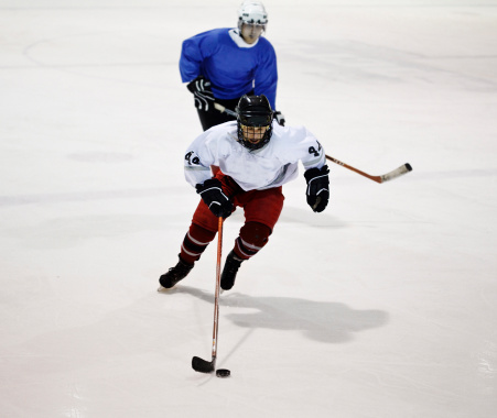 Ice hockey player skating with the puck.