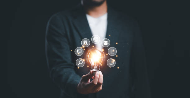 istock Businessman holding glowing lightbulb with learning icons for study knowledge to creative thinking idea and problem solving solution concept. 1467162297