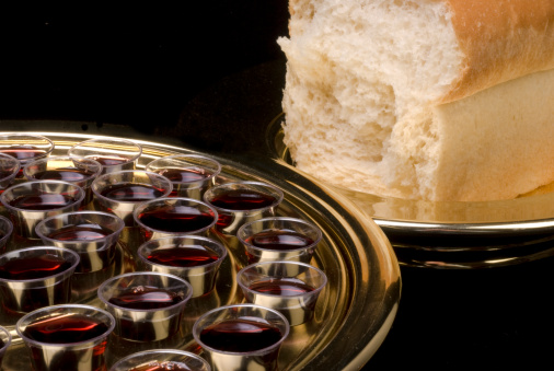 Closeup of communion elements - wine and bread - on a black background