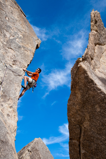 Climber ascends a steep, rock overhang in Joshua Tree National Park, California.