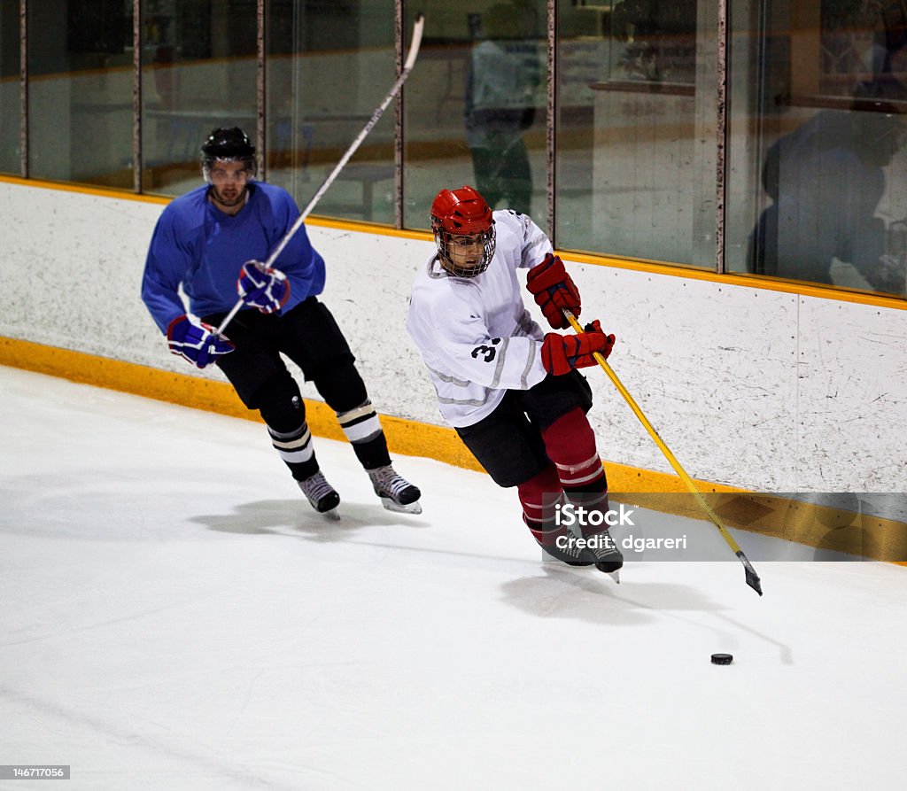 Hockey players from opposite teams Hockey player skating during a game.  Men's Ice Hockey Stock Photo