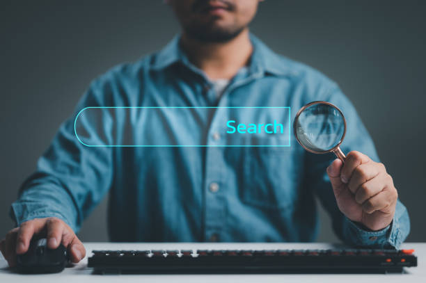istock Businessman use magnifying glass Search On Virtual Screen Data Search Technology Search Engine Optimization. Man use computer to Searching for information. Using Search Console for data, info. 1467171556