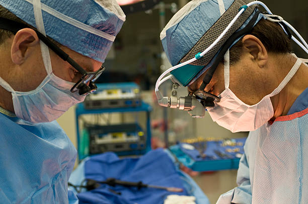 Two surgeons during open heart cardiac bypass surgery stock photo