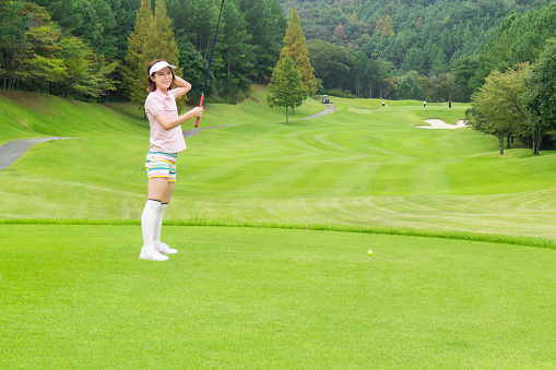 Beautiful young asian woman play golf