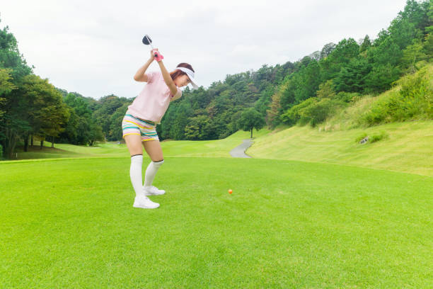 mulher asiática nova jogar golfe - tee box - fotografias e filmes do acervo