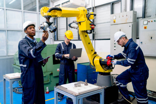 istock African American technician work with his team to check and maintenance robotic arm in factory workplace. 1467184388