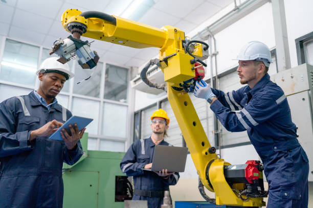 istock Close up view African American technician work with his team to check and maintenance robotic arm in factory workplace. 1467184473