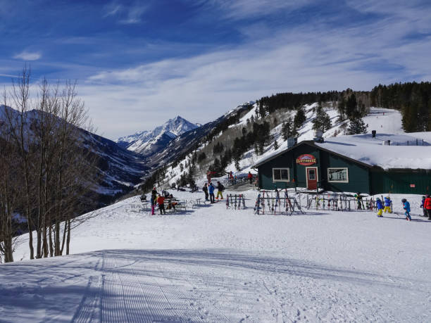 skiers outside mountain top cliff lodge with pyramid peak beyond. buttermilk ski resort, aspen, colorado. - human pyramid imagens e fotografias de stock