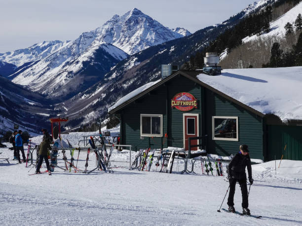 skiers outside mountain top cliff lodge with pyramid peak beyond. buttermilk ski resort, aspen, colorado. - human pyramid imagens e fotografias de stock