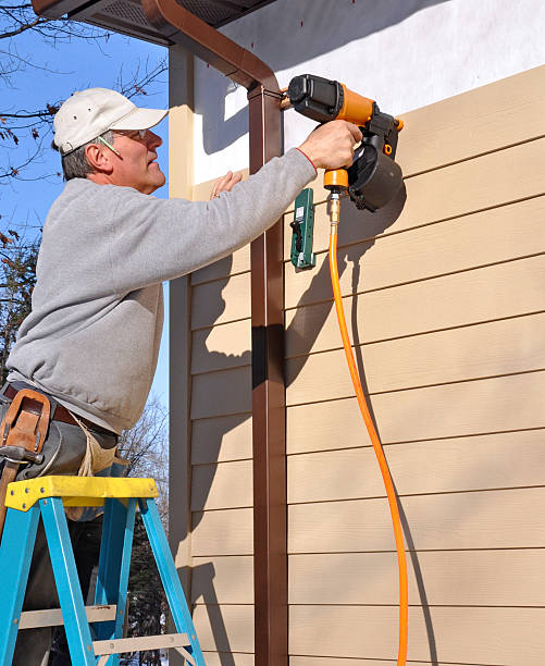 Man installing siding with nail gun Man installing fibrous cement siding with nail gun siding building feature photos stock pictures, royalty-free photos & images