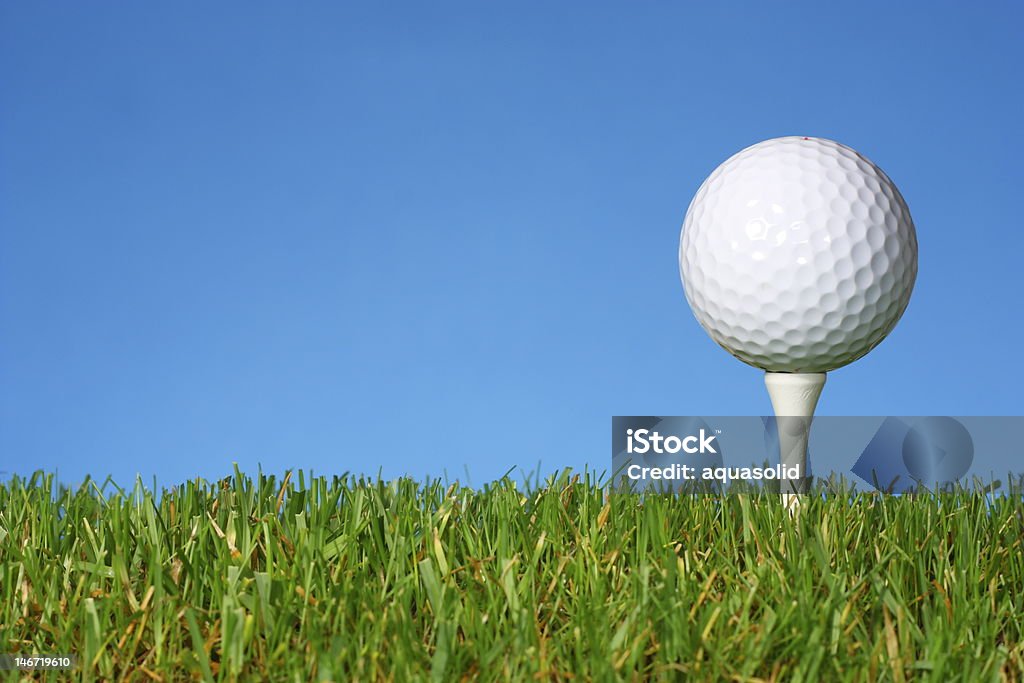 Bianco pallina da Golf su un tee con erba lussureggiante. - Foto stock royalty-free di Erba
