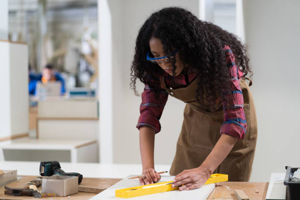 istock Woman carpenter using precision level making furniture at wood workshop 1467202675