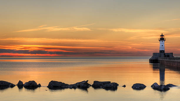 Great Lake Lighthouse Sunrise with Rocks stock photo